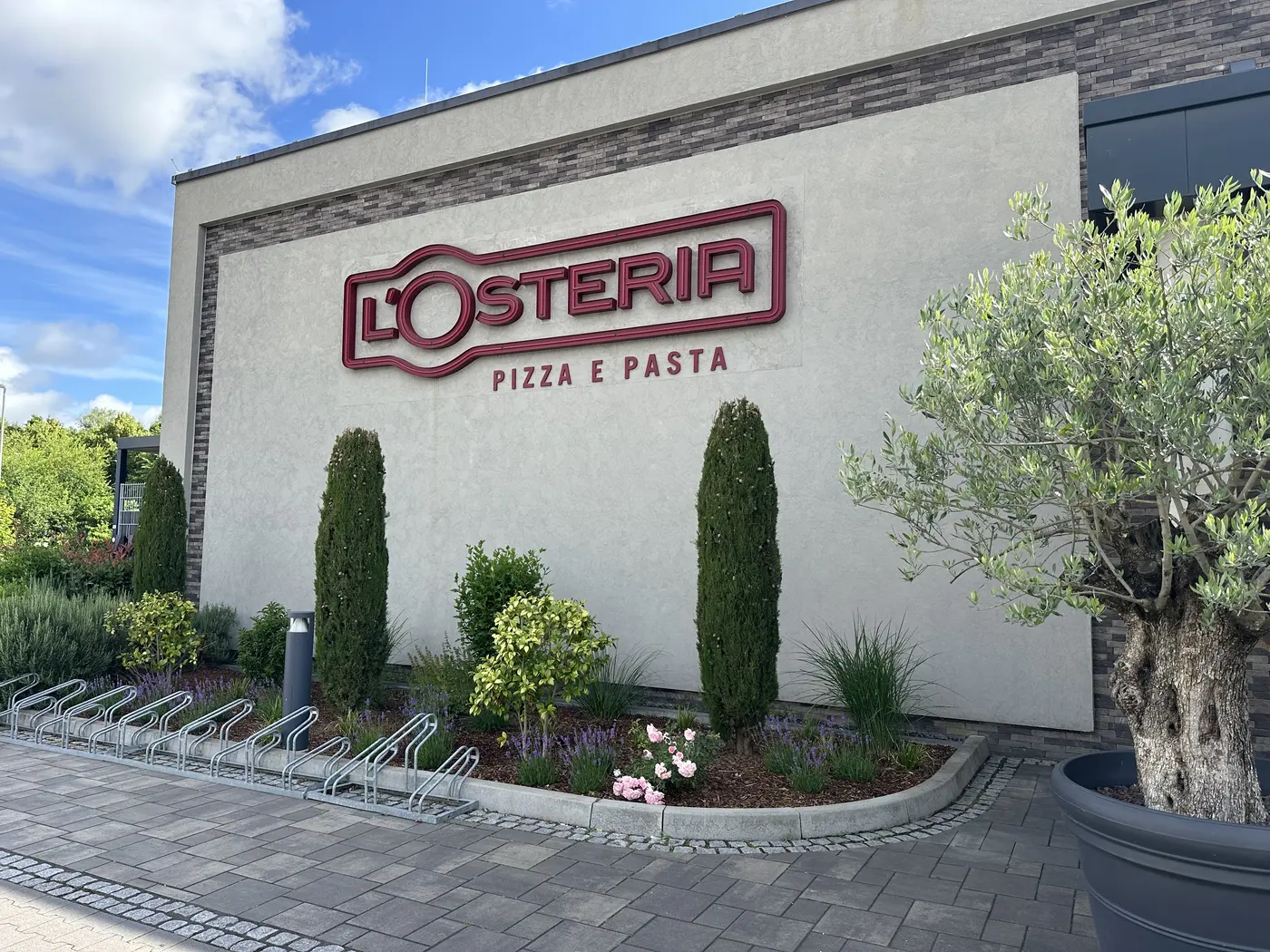 Fertiggestellte Beetgestaltung mit L'Osteria-Schriftzug in Dormagen